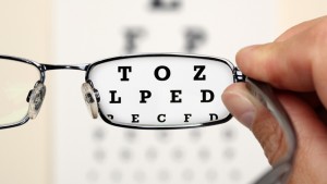 Looking through glasses at an eye exam chart